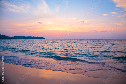 sunset on the sea. sandy beach, clear water, waves. surf line in the warm colors of the setting sun.