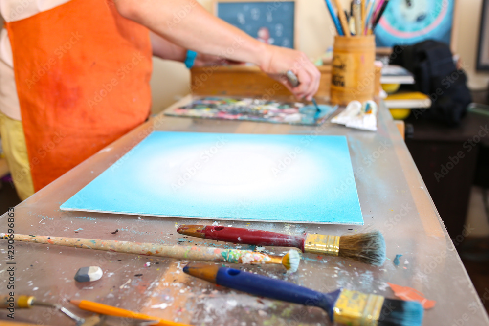 Real work studio of the painter. Man is creating picture. Artist concept. Creative atmosphere. Paint brushes. Real work studio of the painter. Man is creating picture. Artist concept. Creative atmosphere. Paint brushes.