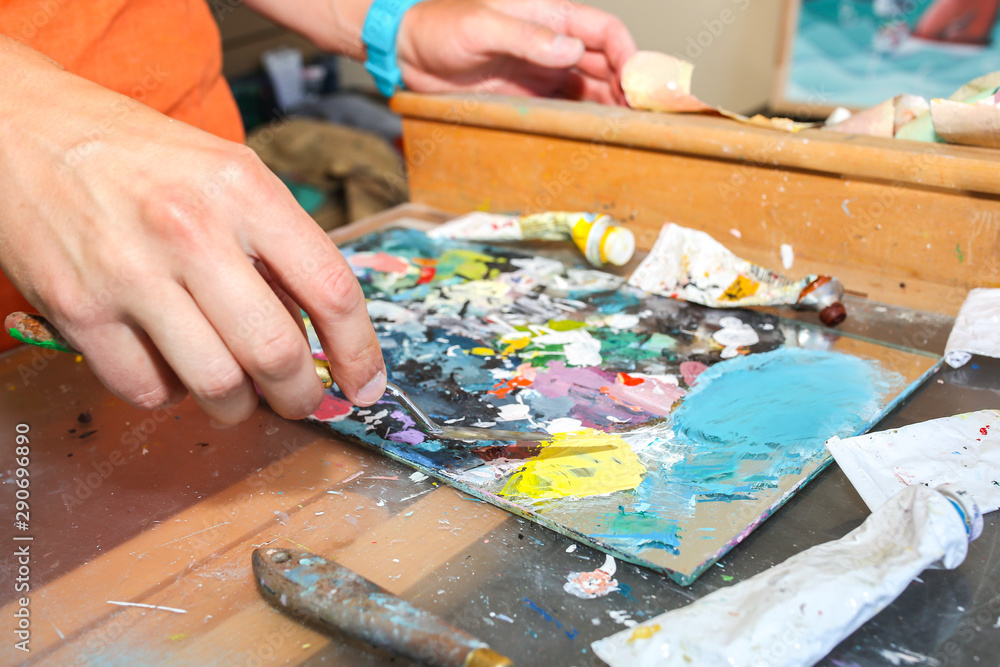 Real work studio of the painter. Man is creating picture. Artist concept. Creative atmosphere. Paint palette knife. Real work studio of the painter. Man is creating picture. Artist concept. Creative atmosphere. Paint palette knife.