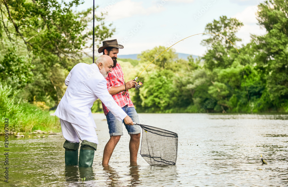 successful catch. hobby of businessman. retirement fishery. friends men with fishing rod and net. Fly fishing adventures. happy fishermen. Good profit. retired dad and mature bearded son successful catch. hobby of businessman. retirement fishery. friends men with fishing rod and net. Fly fishing adventures. happy fishermen. Good profit. retired dad and mature bearded son