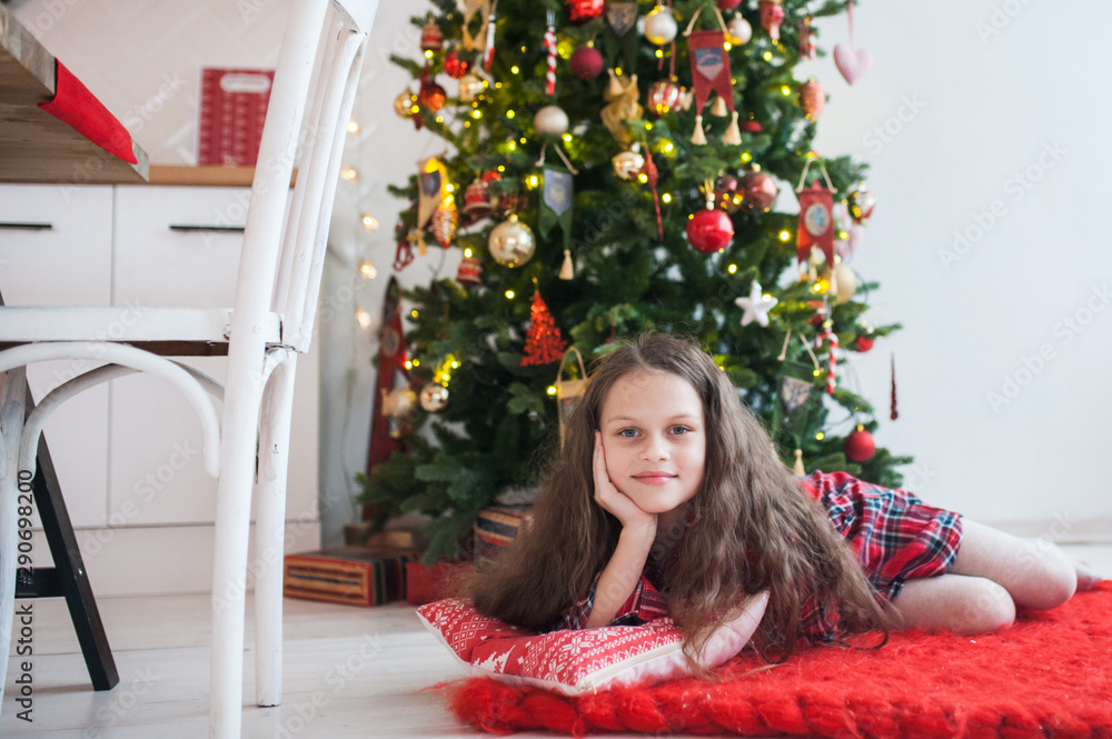 Portrait of a girl sitting in the kitchen decorated for Christmas Portrait of a girl sitting in the kitchen decorated for Christmas