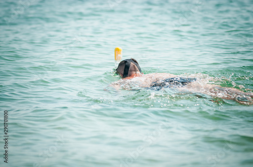 Man swimming with snorkeling mask in the ocean