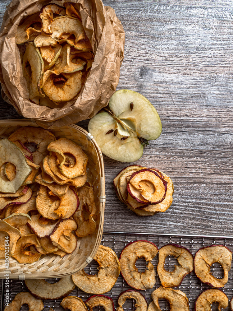 Fototapeta premium Tasty apple chips on wooden table, healthy vegan vegetarian fruit snack or ingredient for cooking