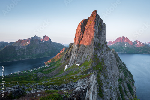 View from Mount Hesten on Iconic Mountain Segla in light of midnightsun in front of clear sky and mountain range in background, Fjordgard, Senja, Norway photo