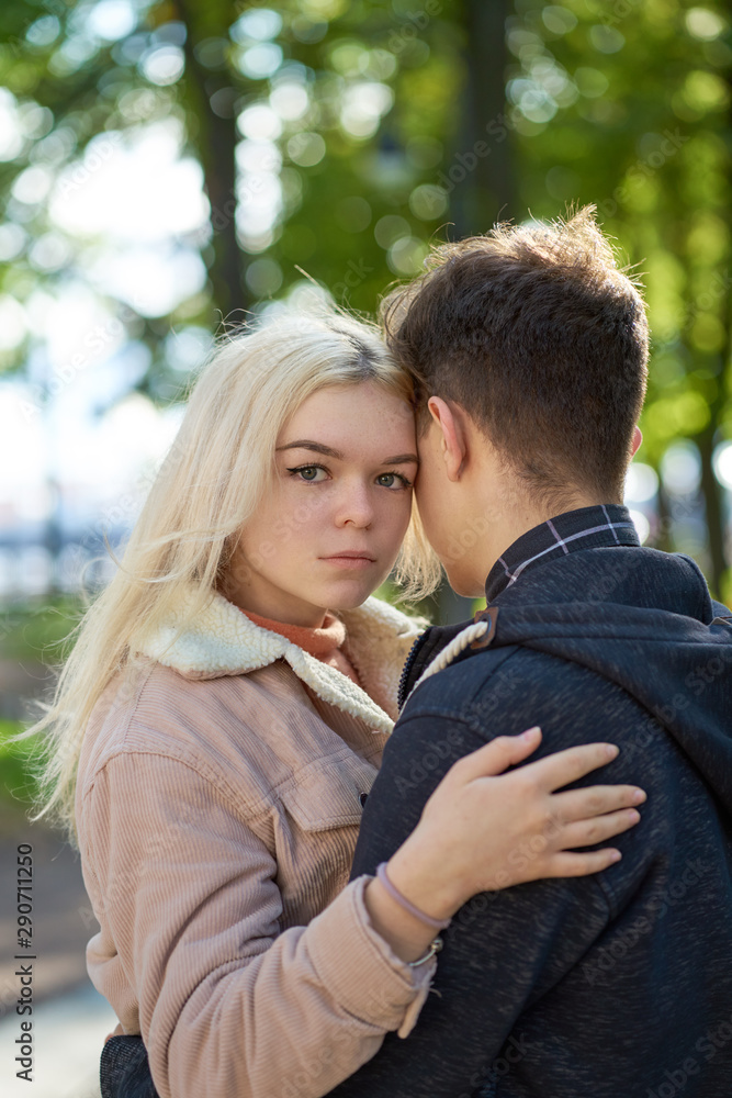 Guy and girl are standing embracing. First love, teenage love, new feelings and relationships. Autumn, Park Guy and girl are standing embracing. First love, teenage love, new feelings and relationships. Autumn, Park