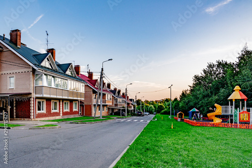  beautiful rural village with two-story houses and trees on a summer day
