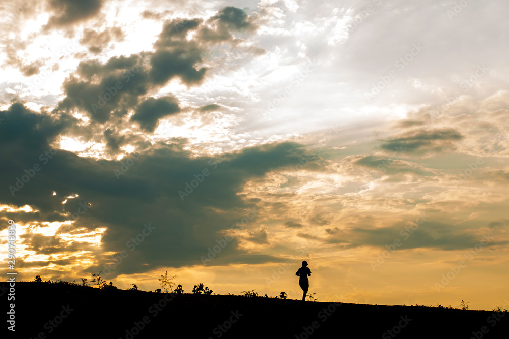 Silhouette women's runners run on hillside at sunset. jogging workout wellness concept.