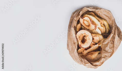 panorama of tasty dried apples chips in paper bag, banner