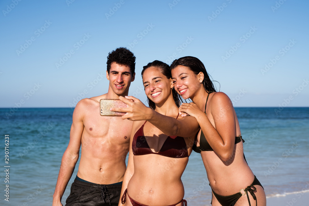 Group of young people taking a photo on the beach