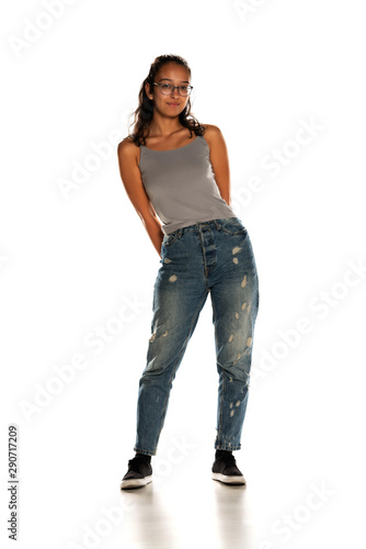 Young Indian woman in jeans standing on white background