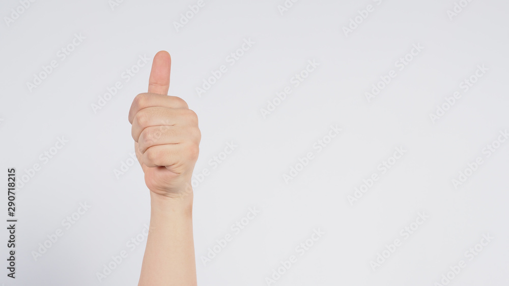 Male's left hand doing thumbs up sign on white background.