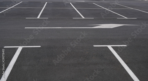 View on empty parking with clear markings and arrows indicating the direction of movement. Modern car parking. Marking on asphalt road. © Olga