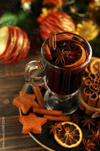 Christmas mulled vine with spices sinnamon stiks, anice stars, orange and New Year decorations on a wooden rustik table. Selective focus. Traditional hot drink at Xmas holiday