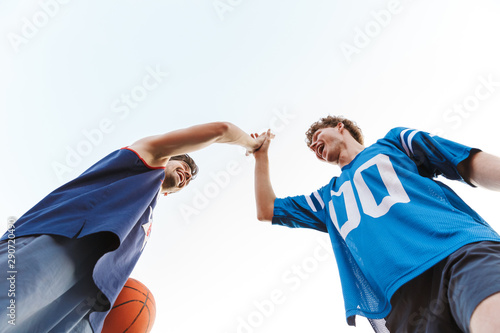 Bottom view of two happy confident basketball players