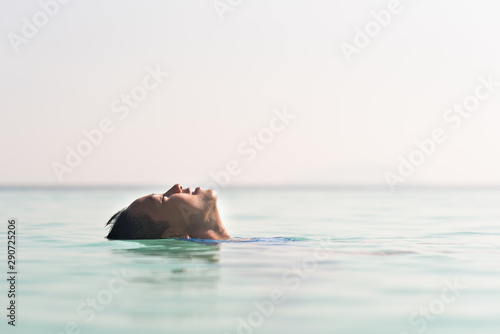 young asian boy floating on a water relaxing in overflow swimming pool. Concept of holiday, relaxation and happiness © Hafiez Razali