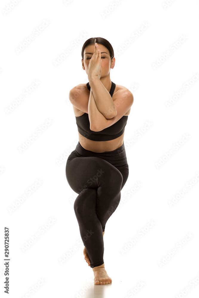 Young yoga woman doing eagle yoga pose. Isolated on white background. Young yoga woman doing eagle yoga pose. Isolated on white background.