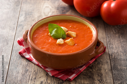 Tomato soup in brown bowl on wooden table