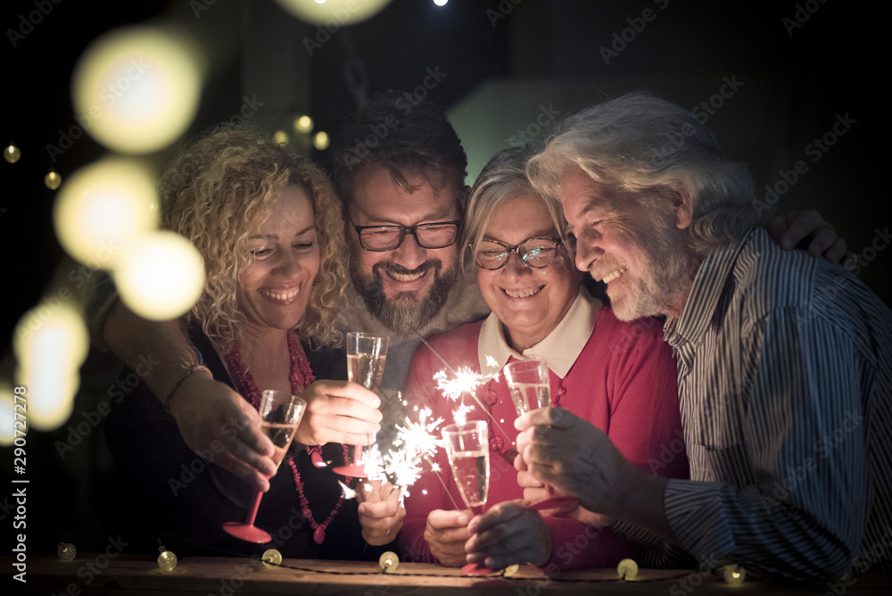 Φωτογραφία group of two seniors and two adults together having fun with sparlers the new ye