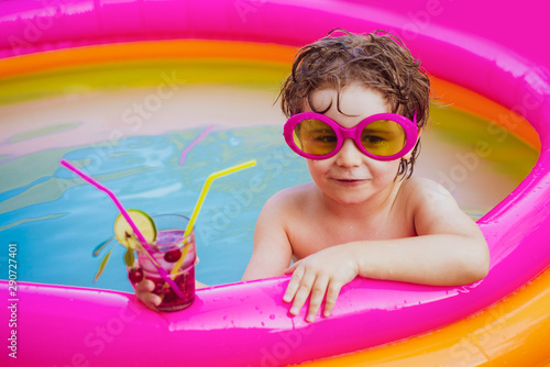 Relax in spa swimming pool. Happy little boy relaxing in pool. Little child boy having fun in the pool. Boy happy swimming in a pool. Kids happy. © Volodymyr
