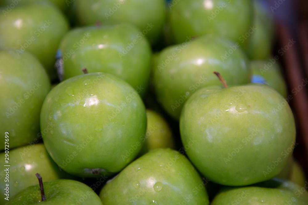 heap of green apples fruits in market .