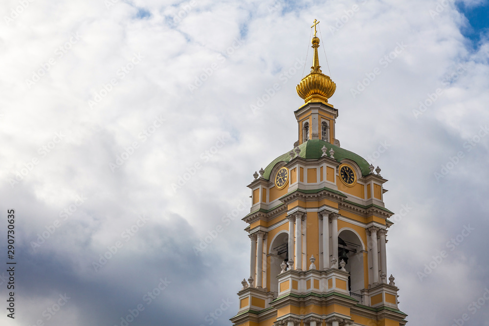 The bell tower of the Novospassky Monastery with a clock against a picturesque cloudy sky The bell tower of the Novospassky Monastery with a clock against a picturesque cloudy sky