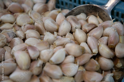 heap of garlic vegetable and scoop in market .