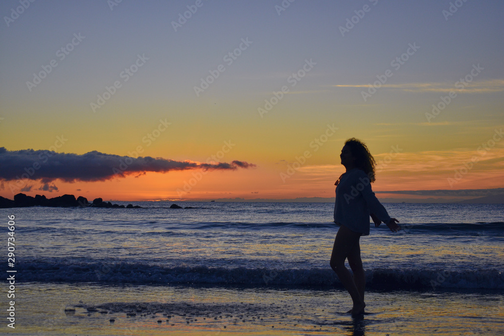 funny girl at sunset on the beach