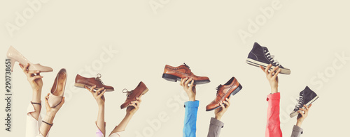 Hands holding different shoes on isolated background