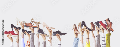 Hands holding different shoes on isolated background