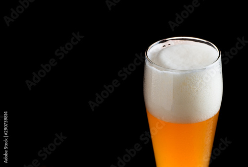 A glass of wheat beer on a dark background close-up with copyspace
