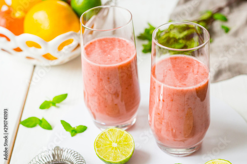 Two Glasses of Smoothie with Berries, Grapefruit, Lemon, Lime and Mint on White Wooden Background, Detox Time