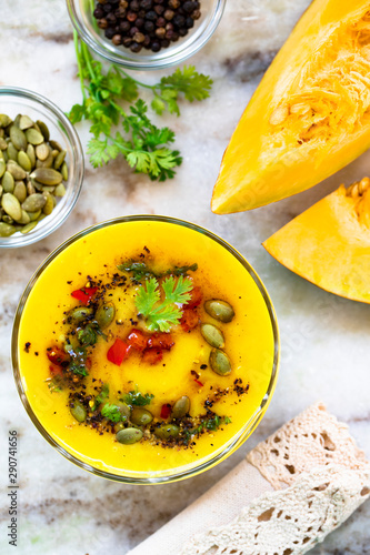 pumpkin soup with pumpkin seeds and pieces of fresh pumpkin on a marble table top view.