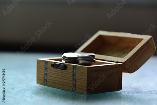 A lot of coins in wooden box/saving concept