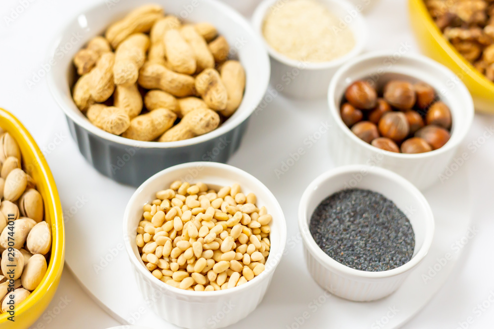 Various Nuts and Seeds on White Background in the Bowls - Image Various Nuts and Seeds on White Background in the Bowls - Image