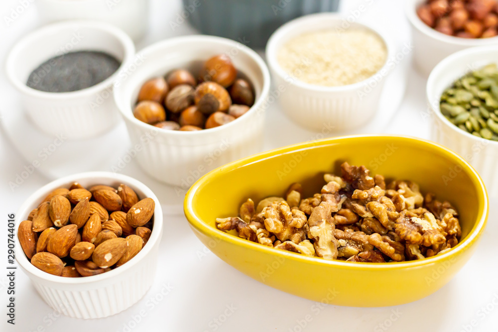 Various Nuts and Seeds on White Background in the Bowls - Image Various Nuts and Seeds on White Background in the Bowls - Image