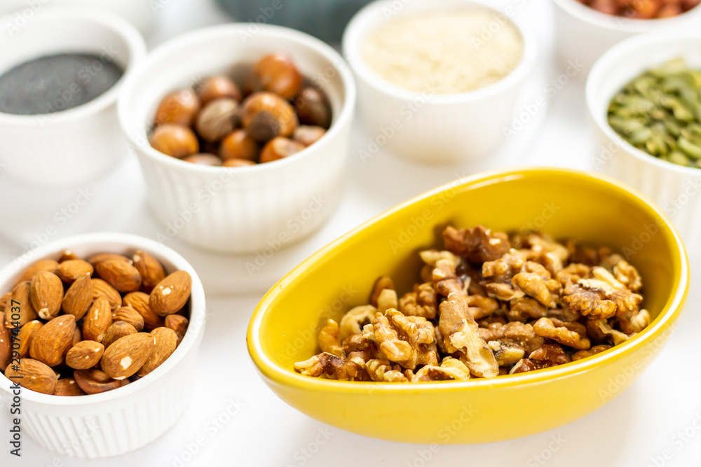 Various Nuts and Seeds on White Background in the Bowls - Image Various Nuts and Seeds on White Background in the Bowls - Image