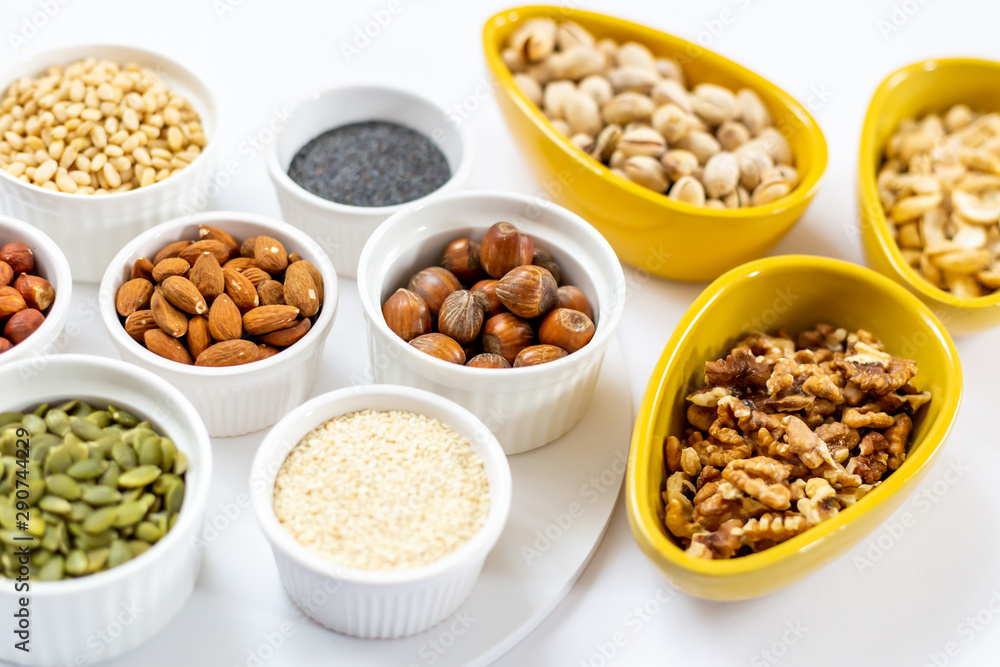 Various of Nuts and Seeds on White Background in the Bowls - Image Various of Nuts and Seeds on White Background in the Bowls - Image