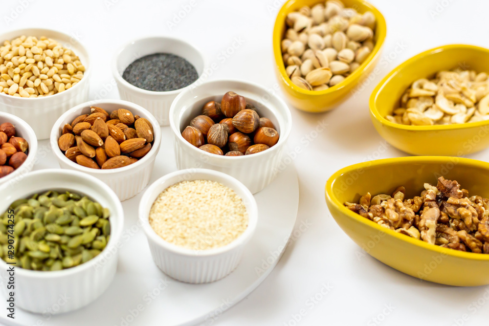 Various of Nuts and Seeds on White Background in the Bowls - Image Various of Nuts and Seeds on White Background in the Bowls - Image