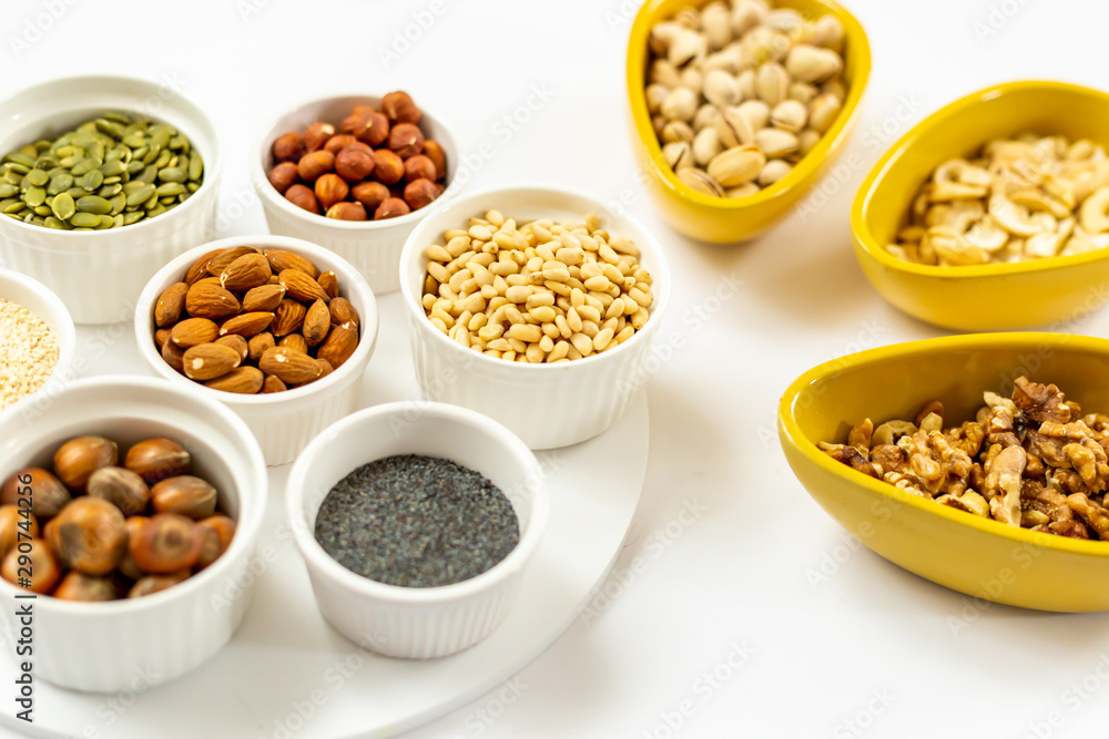Various of Nuts and Seeds on White Background in the Bowls - Image Various of Nuts and Seeds on White Background in the Bowls - Image