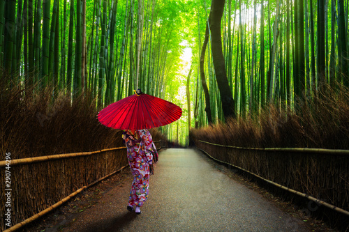 Bamboo forest at Arashiyama with woman in traditional kinono and umbrella. Japan