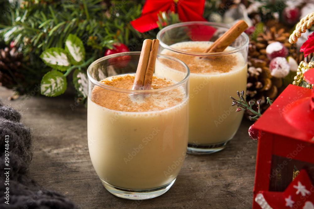 Homemade eggnog with cinnamon in glass on wooden table. Typical Christmas dessert. Homemade eggnog with cinnamon in glass on wooden table. Typical Christmas dessert.