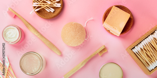 A panorama of plastic-free, zero waste cosmetics, flat lay pattern on a pink background. Bamboo toothbrushes and cotton swabs, konjac sponge, natural organic products
