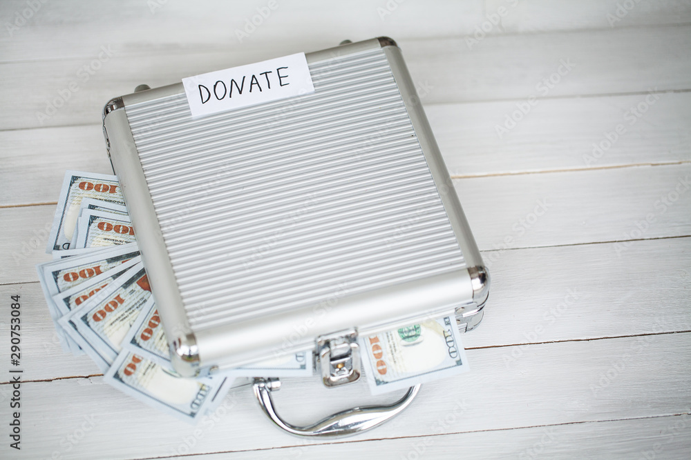 Donate conception. Box with money on white wood background Donate conception. Box with money on white wood background
