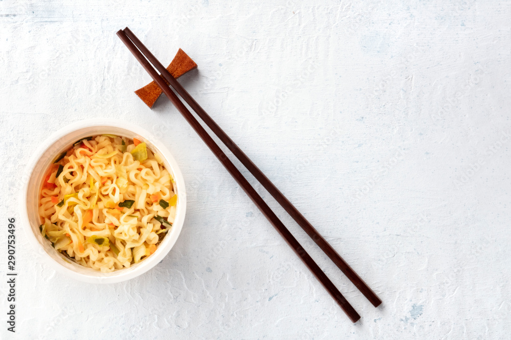 Plastic cup of instant ramen noodles, shot from above with chopsticks and a place for text Plastic cup of instant ramen noodles, shot from above with chopsticks and a place for text