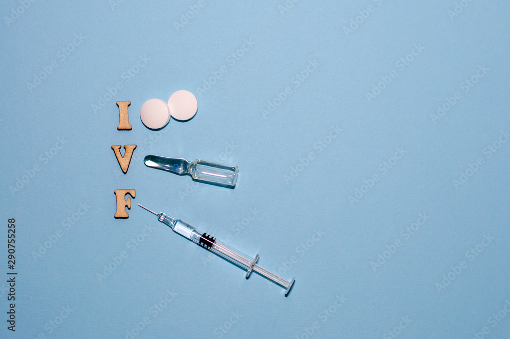 The abbreviation IVF is laid out in wooden letters on a blue background. In  vitro injection