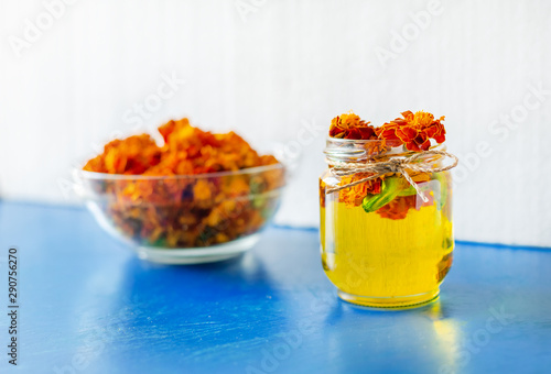 Processing of dried flowers marigolds. Bottle of Chornobrivtsi essential oil . photo