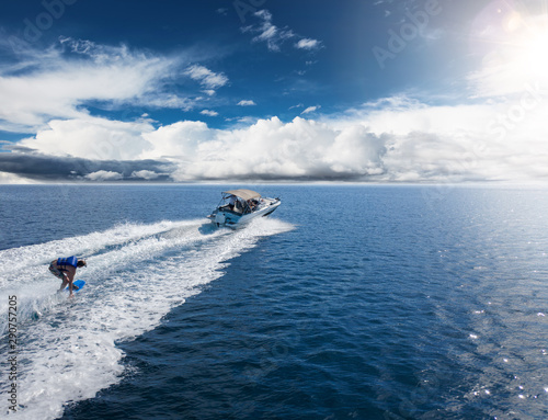Fotografie Speedboat with wakeboard rider on open sea