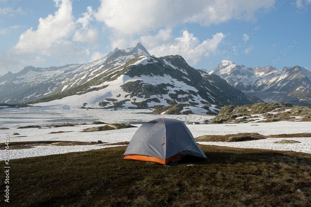 Bivouac in the snowy mountains with an orange-gray tent