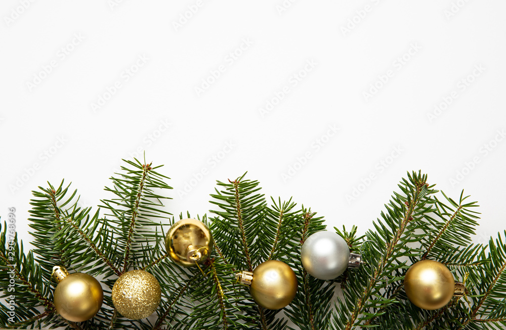 Fir twig and christmas baubles, white background