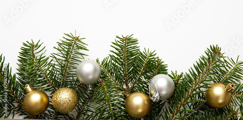 Фотография Fir twig and christmas baubles, white background